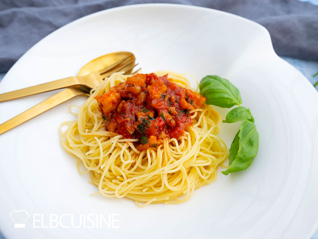 Spaghetti mit Garnelen-Bolognese auf einem Teller angerichtet. Tim Mälzer